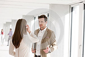 Young businessman talking with female colleague in new office