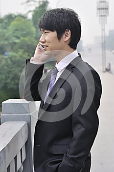 Young businessman talking on mobile phone.