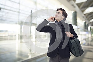 Young businessman talking on mobile phone in airport