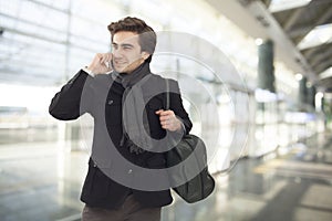 Young businessman talking on mobile phone in airport