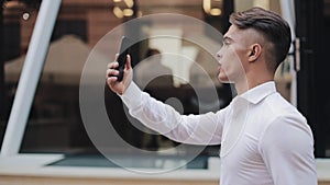 Young businessman talking on smartphone having video chat business meeting. Smiling business man in video conference