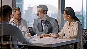 Young businessman talking to business people colleagues or partners sitting at conference table