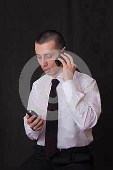 Young businessman talking on two phones