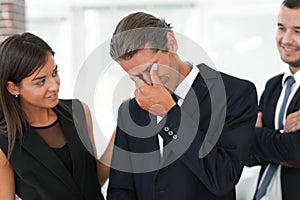 Young businessman with tears of joy and his business team