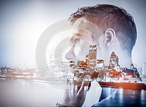 Young businessman thinking. Double exposure city background.