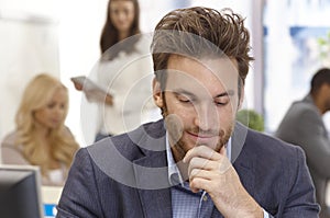 Young businessman thinking in office