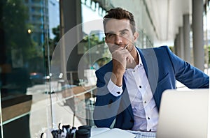 Young businessman thinking about work at a cafe table