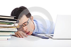 Young businessman too weary to asleep on the desk