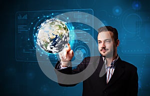 Young businessman touching high-tech 3d earth panel
