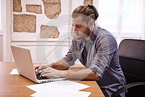 Young businessman typing on his laptop