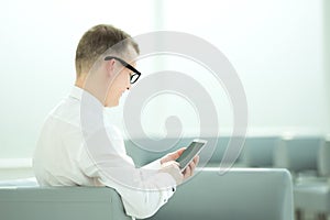 Young businessman typing SMS on his smartphone.