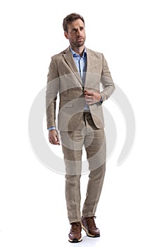 Young businessman unbuttoning his jacket, looking away