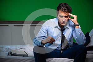 Young businessman under stress in the bedroom at night