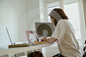 Young businessman using computer working remotely from modern home office. Distance work concept