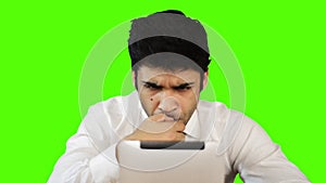 Young businessman using digital tablet on green background