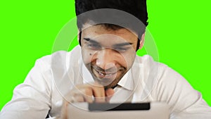 Young businessman using digital tablet on green background