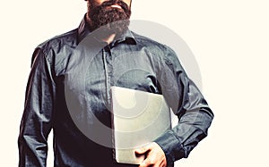 Young businessman using his laptop, pc. Holding laptop computer. Serious handsome bearded man worker laptop