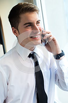 Young businessman using his mobile phone in office.