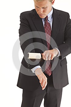 Young businessman using lint brush