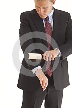 Young businessman using lint brush photo