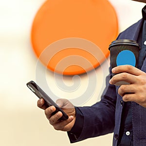 Young businessman using mobile phone at coffee shop and drinking coffee