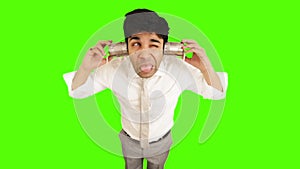 Young businessman using tin can phone on green background