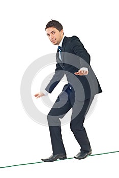 Young businessman walking on tightrope