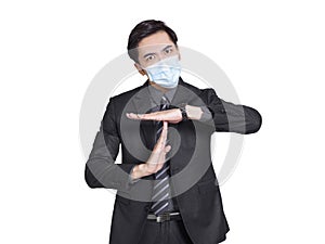 Young businessman wearing medical mask tired and bored, making a timeout gesture, needs to stop because of work stress photo
