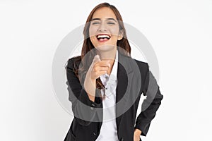 young businessman wearing suit pointing at camera with offensive laughing expression