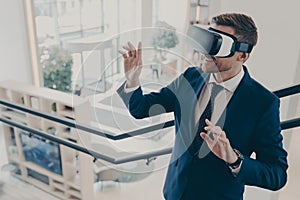 Young businessman wearing virtual reality goggles working in office