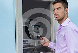 Young businessman withdrawing money from a cash machine
