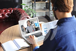 Young businessman working on computer, doing video conference with collegues on laptop. Distance work. Coronavirus