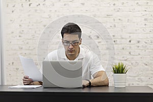 Young businessman working on laptop at home, distant work