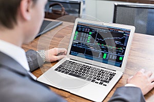 Young businessman working with laptop, man`s hands on notebook computer.