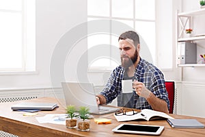 Young businessman working with laptop in modern white office