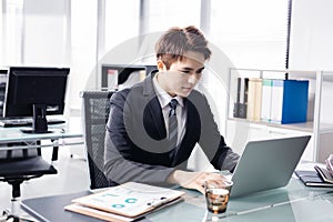 Young businessman working with laptop in office