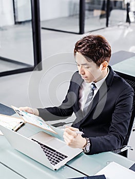 Young businessman working with laptop in office