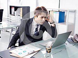 Young businessman working with laptop in office