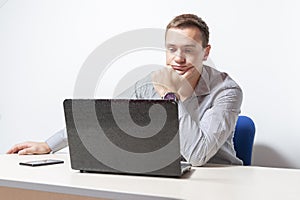 Young businessman working on laptop in office, being concerned