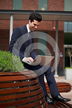 Young businessman working on laptop outside the office