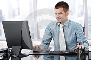 Young businessman working in modern office smiling