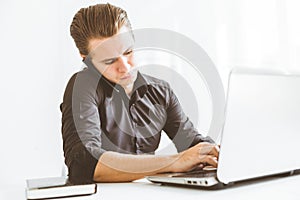 Young businessman working in the office at the laptop