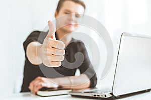 Young businessman working in the office at the laptop