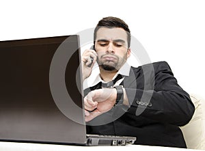 Young businessman working overtime focus on watch photo