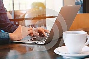 Young businessman working remotely with computer laptop and coffee at home office during the spread of pandemic Covid-