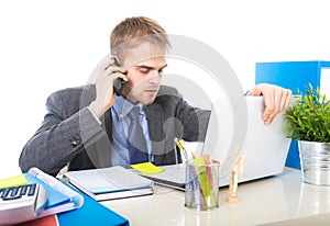 Young businessman worried tired talking on mobile phone in office suffering stress