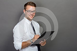 Young businessman writing on a clipboard