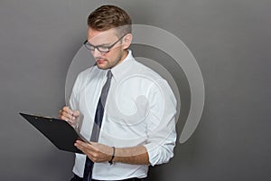 Young businessman writing on a clipboard