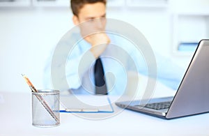 Young businessman writing on clipboard