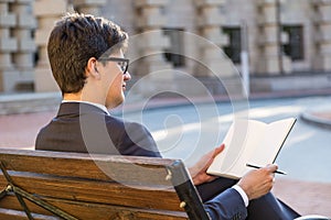 Young businessman writing in notepad